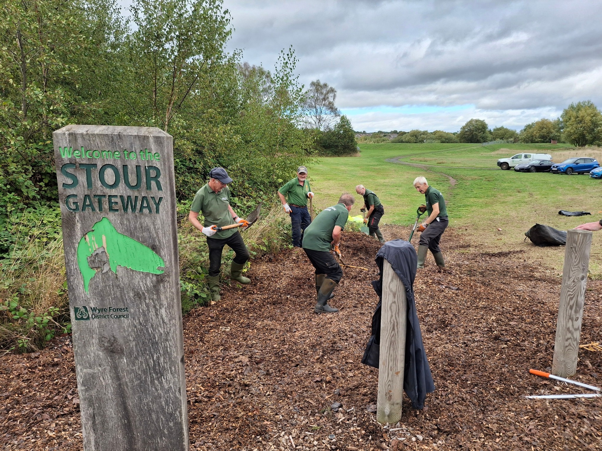 A group of volunteers at a nature reserve using shovels to dig the ground