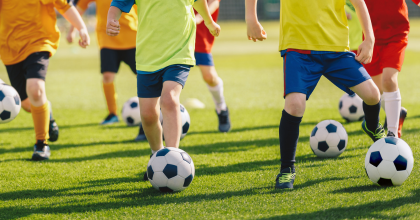 Close up of young footballers practising their dribbling skills